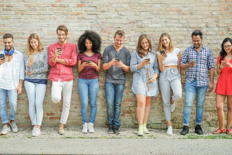 consumer-pr-photo-of-people-lined-up-against-a-wall-on-their-phones