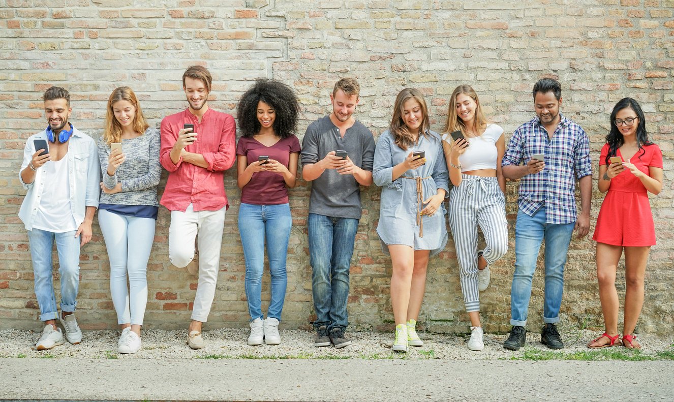 consumer-pr-photo-of-people-lined-up-against-a-wall-on-their-phones