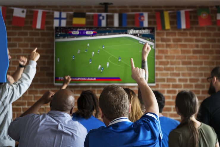 Friends-cheering-at-sport-game-on-tv-at-bar
