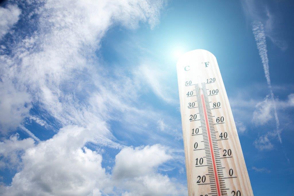 Tall-thermometer-standing-against-a-blue-sky-with-clouds-backdrop