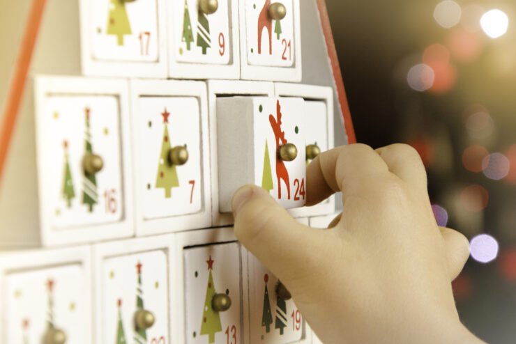 Child's-hand-pulling-the-last-drawer-of-a-wooden-advent-calendar