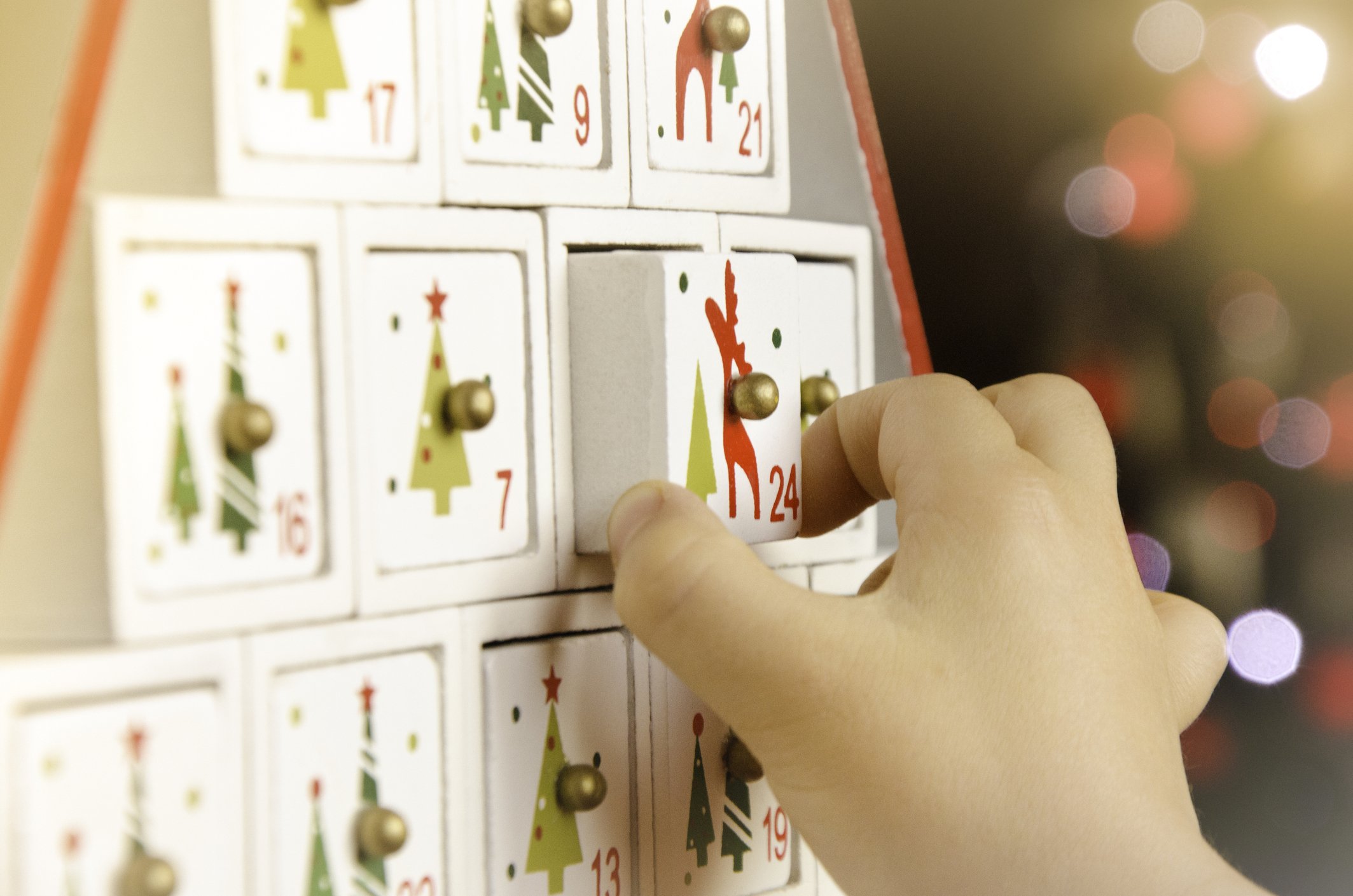 Child's-hand-pulling-the-last-drawer-of-a-wooden-advent-calendar