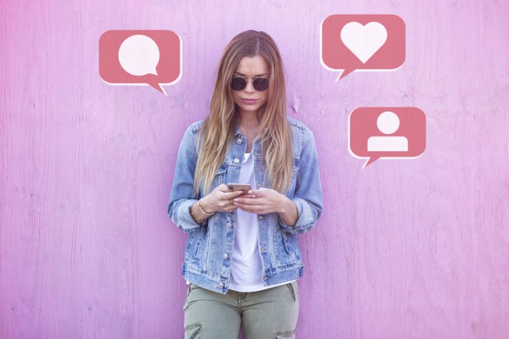 influencer-using-social-media-on-smartphone with-like-comment-follower-icon-around-on-pink-background