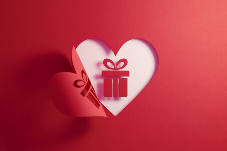 Gift-box-icon-inside-of-a-red-folding-heart-shape-on-white-background