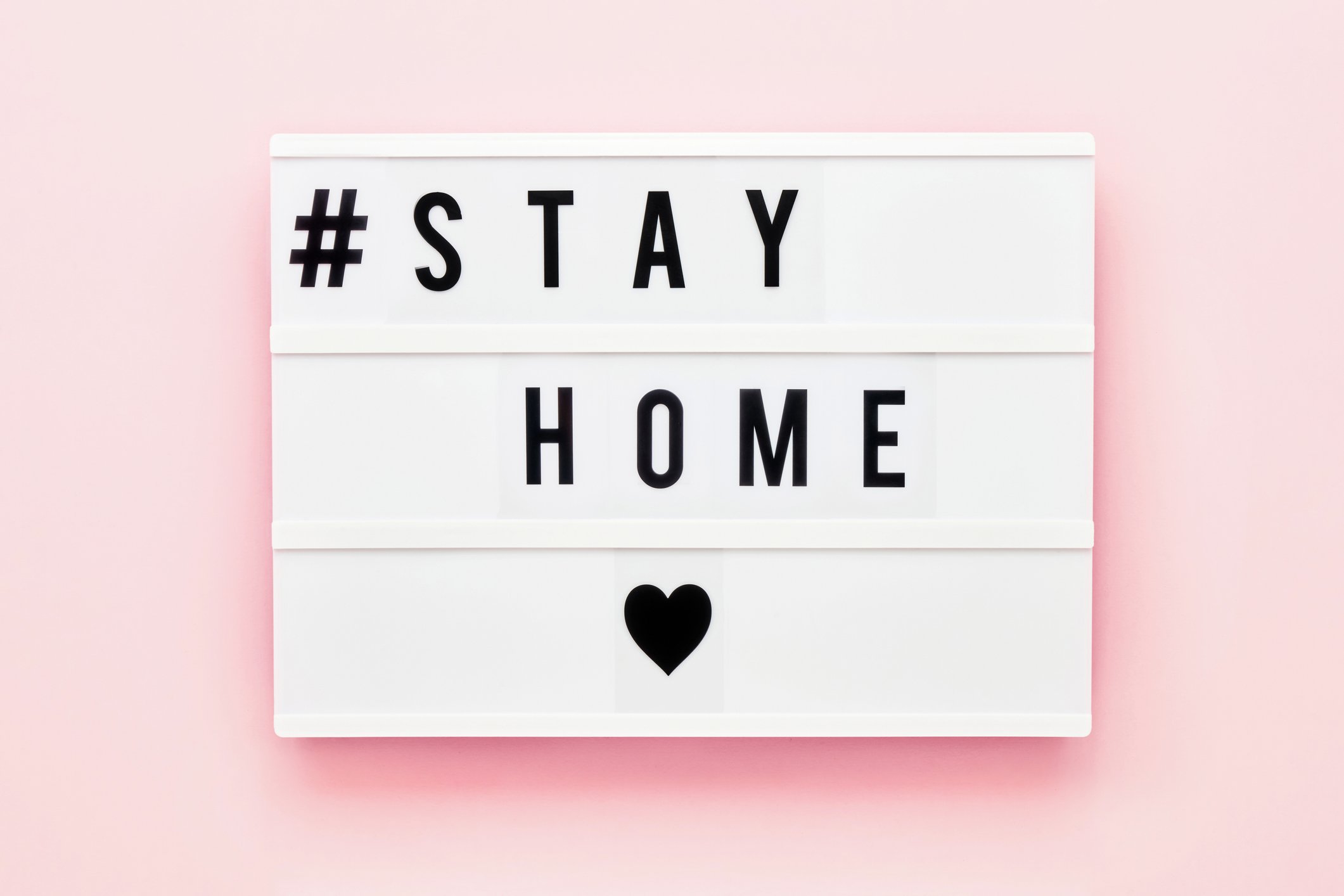 stay-home-written-on-light-box-on-pink-background