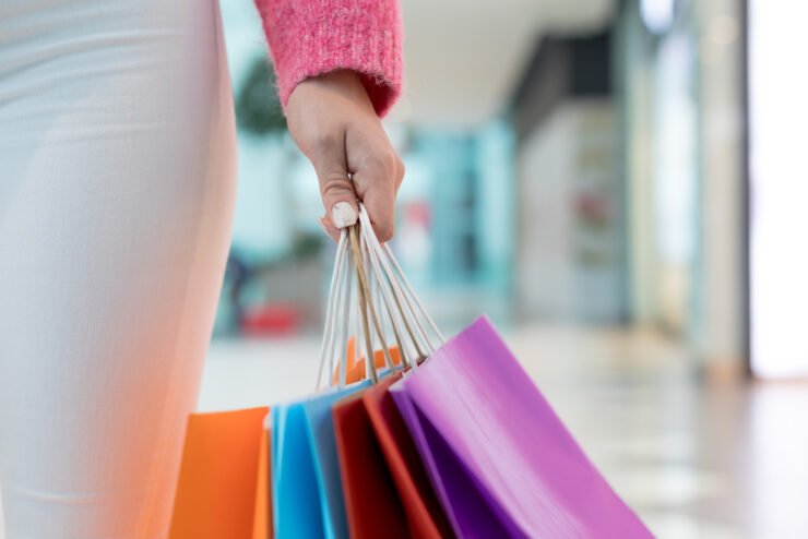 woman-holding-colourful-shopping-bags-in-mall
