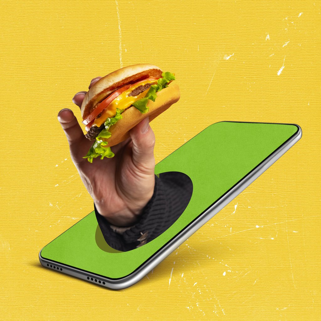 food-pr-shot-of-hand-holding-a-burger-coming-out-of-a-smartphone