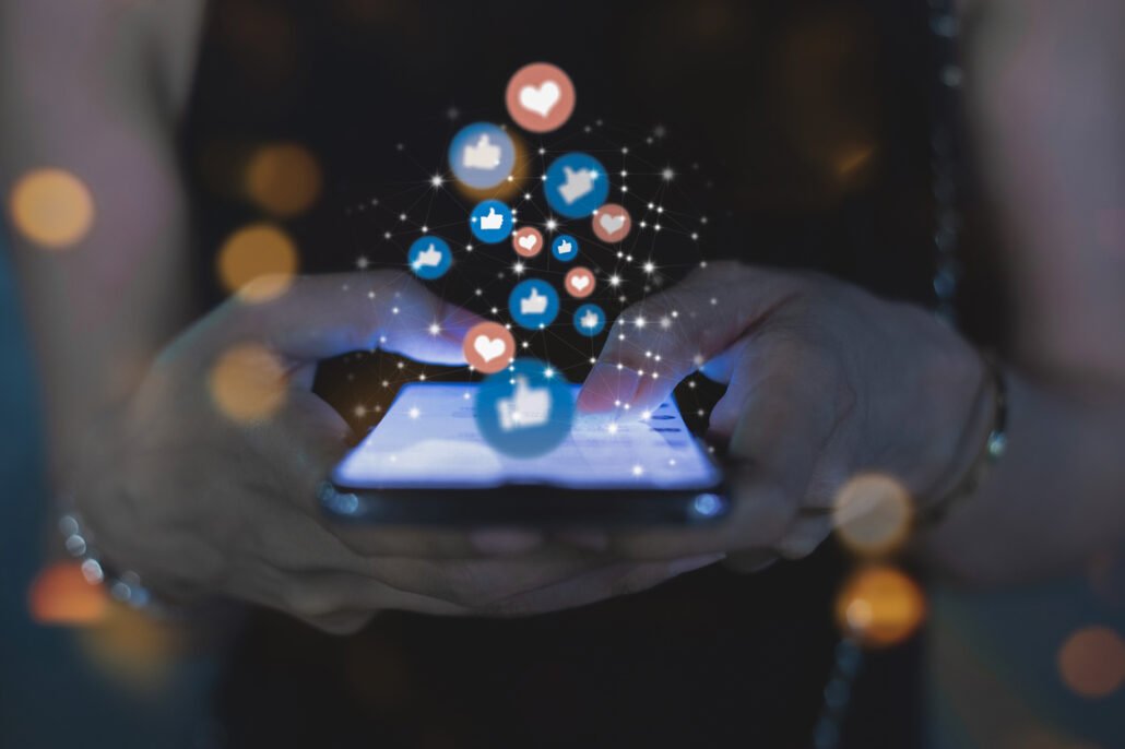 hands-holding-a-smartphone-with-social-media-icons-floating-out-of-the-screen