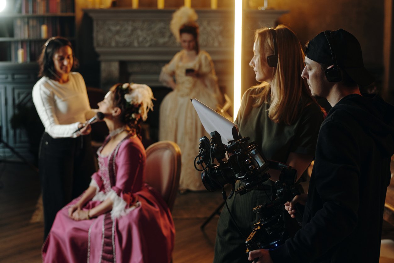 Film-set-for-a-period-drama-actress-having-makeup-applied-film-makers-standing-by