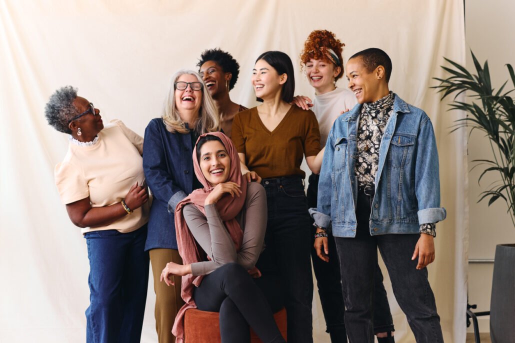 Portrait-of-cheerful-mixed-age-range-multi-ethnic-women-celebrating-International-Women's-Day