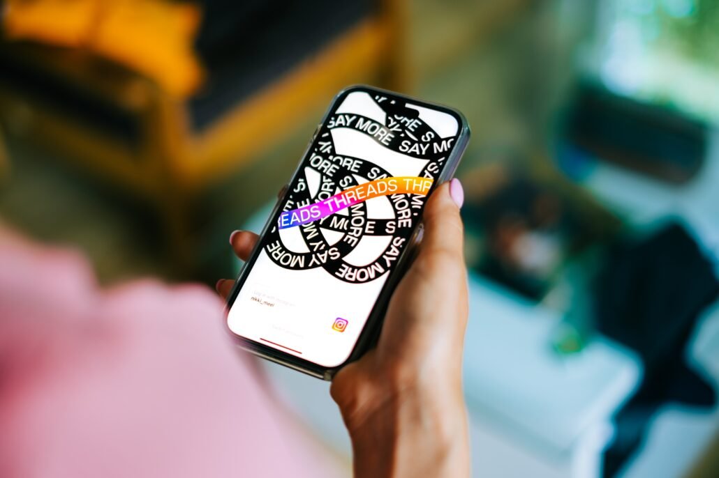 Hands-holding-iPhone-with-Meta-Threads-App-open