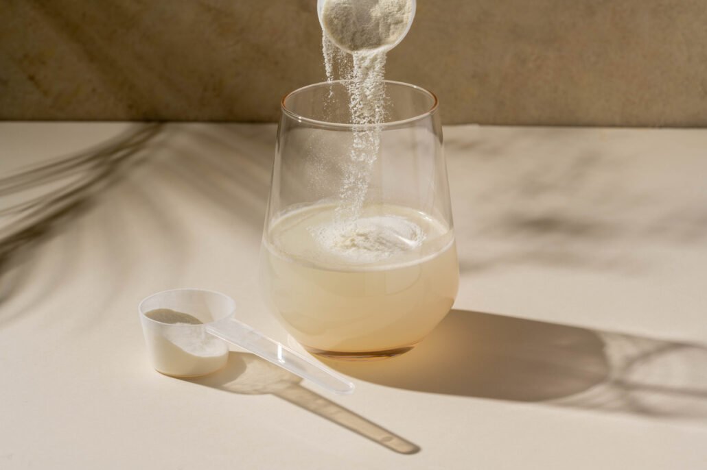 Nutrition-and-food-supplement-powder-added-with-measuring-scoop-in-a-glass-of-water.